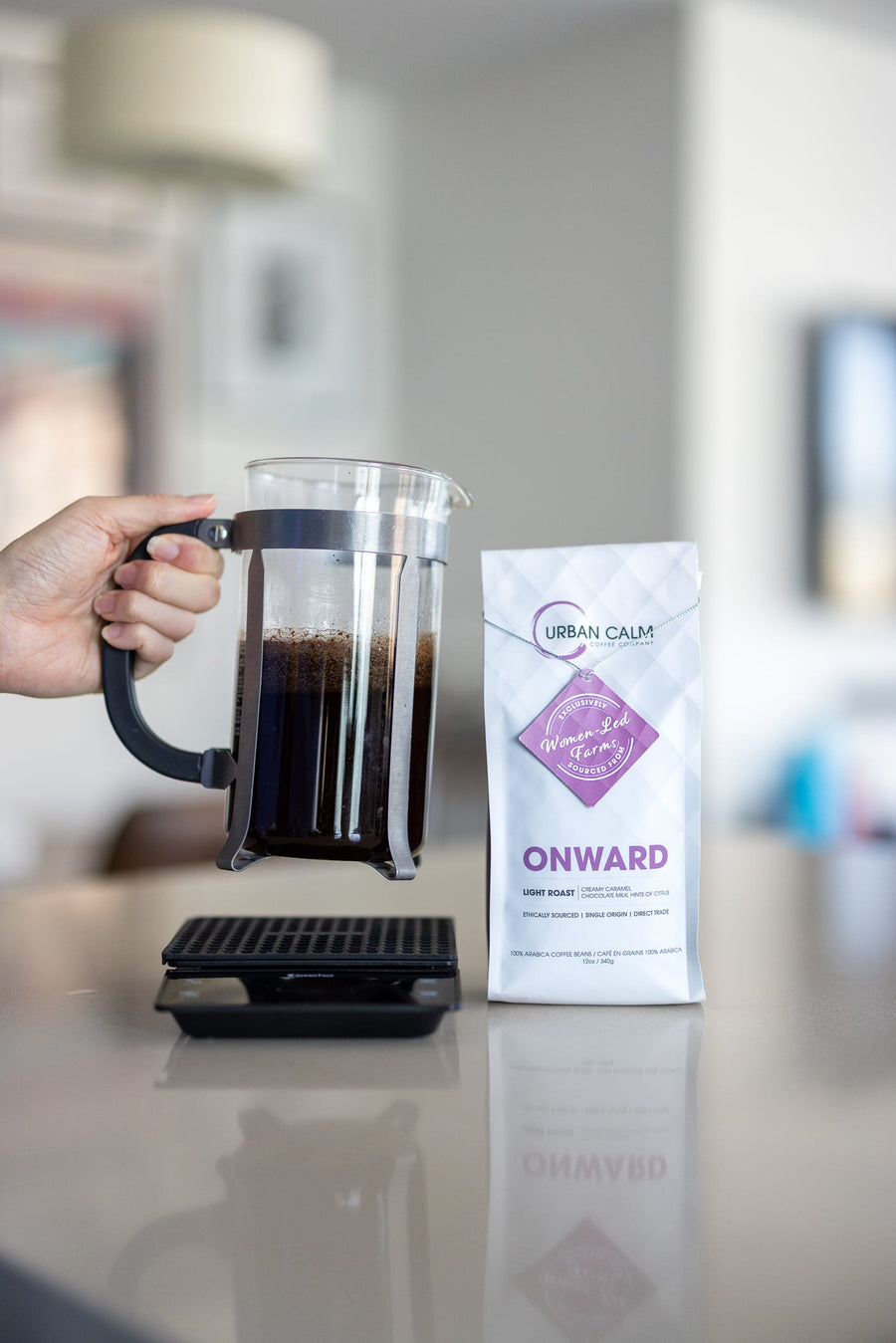 Onward light roast specialty coffee beside a French press