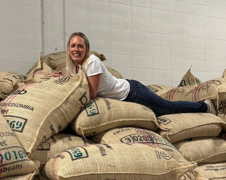 Urban Calm founder Tara Duncan with Colombian green coffee sacks in Calgary