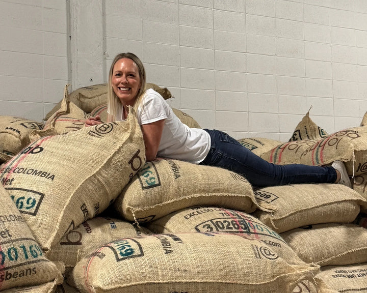 Urban Calm founder Tara Duncan with Colombian green coffee sacks in Calgary